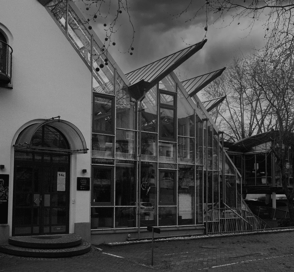 Modernes Bürogebäude mit großer Glasfassade und schräg auskragenden Dächern