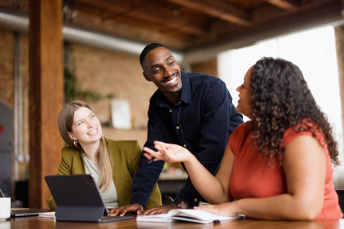 Lachendes Team bespricht sich im Büro