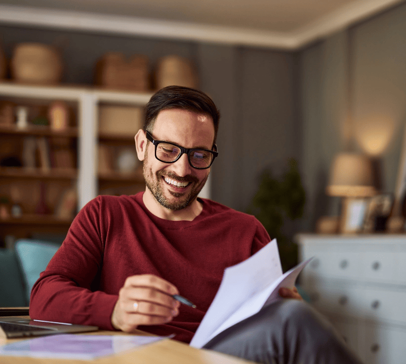 Buchhalter mit Brille prüft Entgeltbescheinigungen und Finanzberichte im Homeoffice